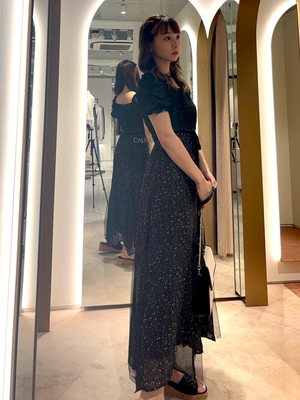 ホワイト系のハンドバッグ、ホワイト系のワンピースを着用したレディースの夏コーディネートの2枚目の写真