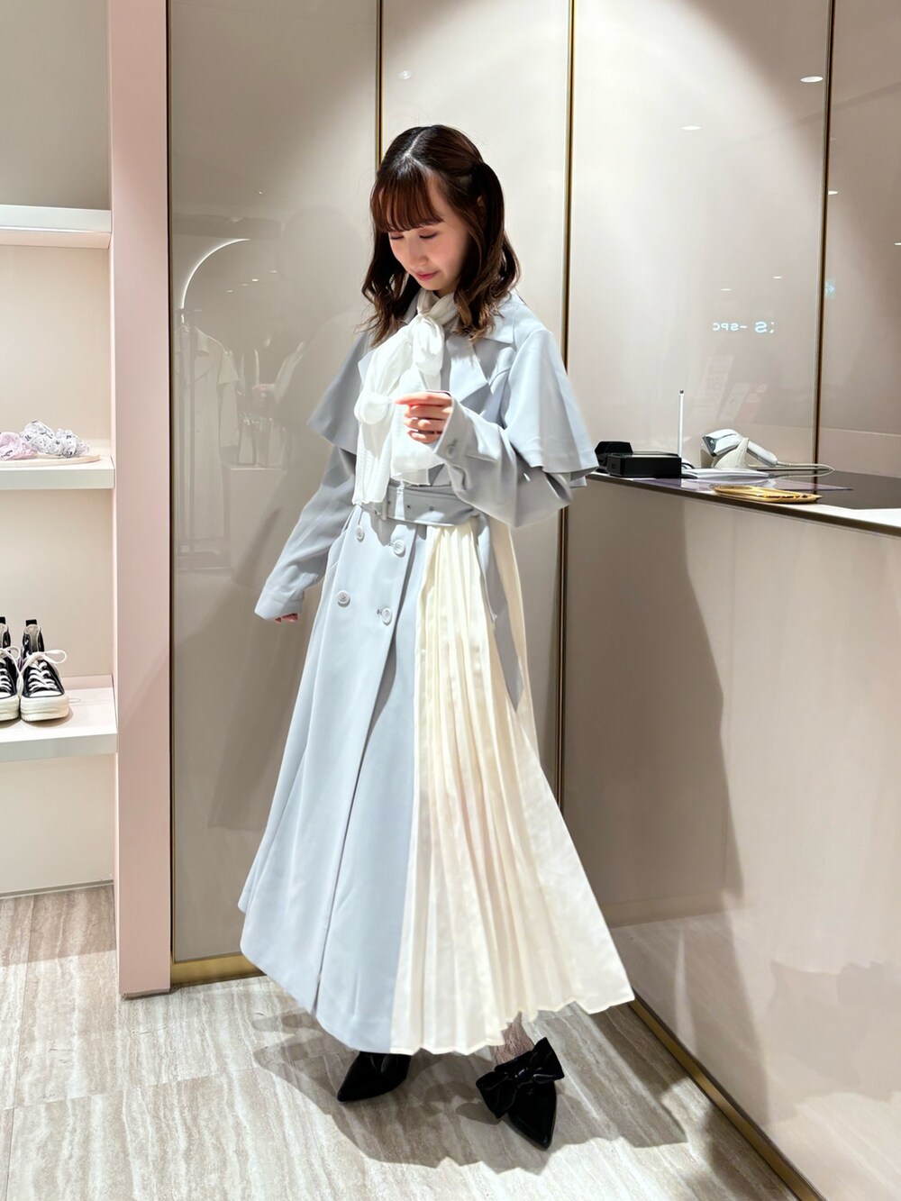 ブルー系のトレンチコート、ホワイト系のシャツ/ブラウスを着用したレディースの春コーディネートの2枚目の写真