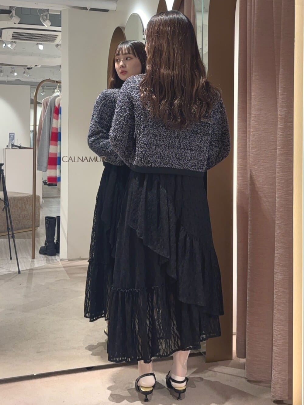 ブラック系のサンダル、ブラック系のスカート、ブラック系のカーディガン/ボレロを着用したレディースの春コーディネートの3枚目の写真