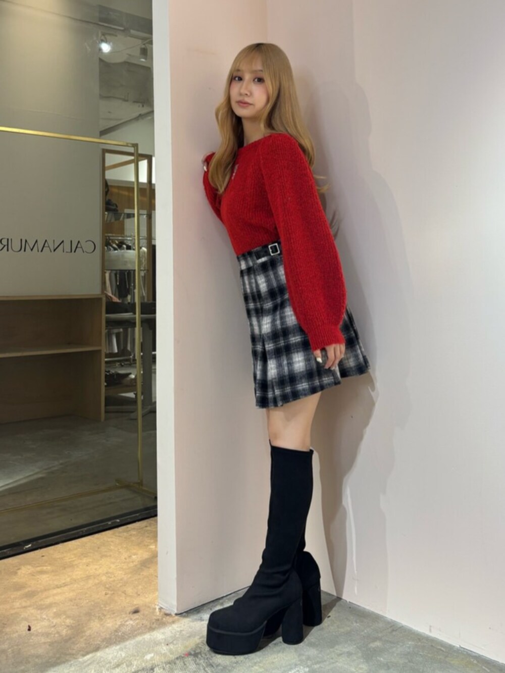 ブラック系のブーツ、レッド系のニット/セーター、その他のスカートを着用したレディースの秋コーディネートの4枚目の写真