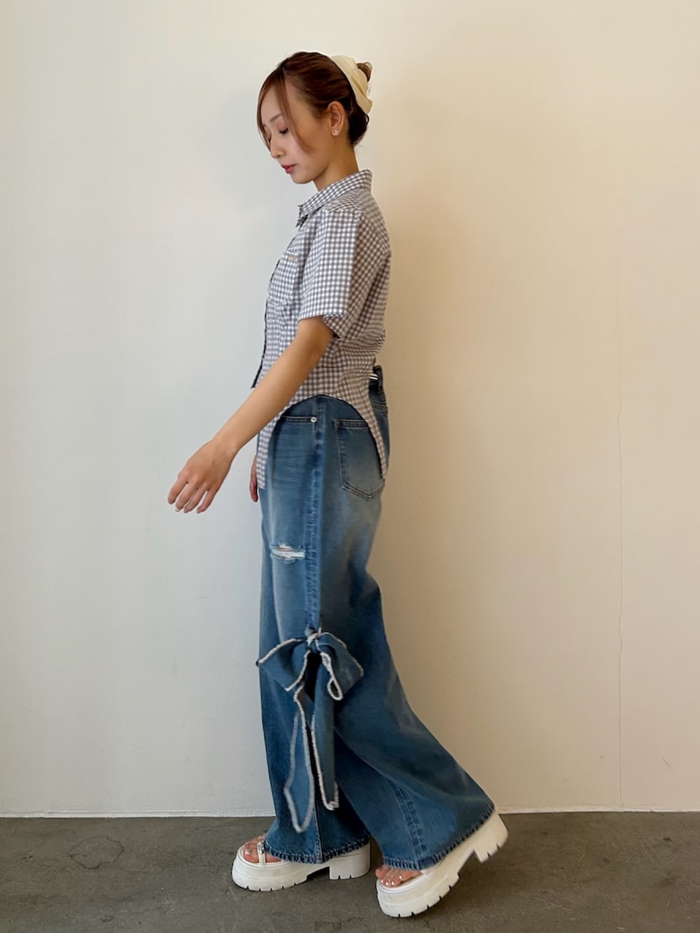 グレー系のシャツ/ブラウス、ブルー系のデニムパンツ、ホワイト系のサンダルを着用したレディースの春コーディネートの2枚目の写真