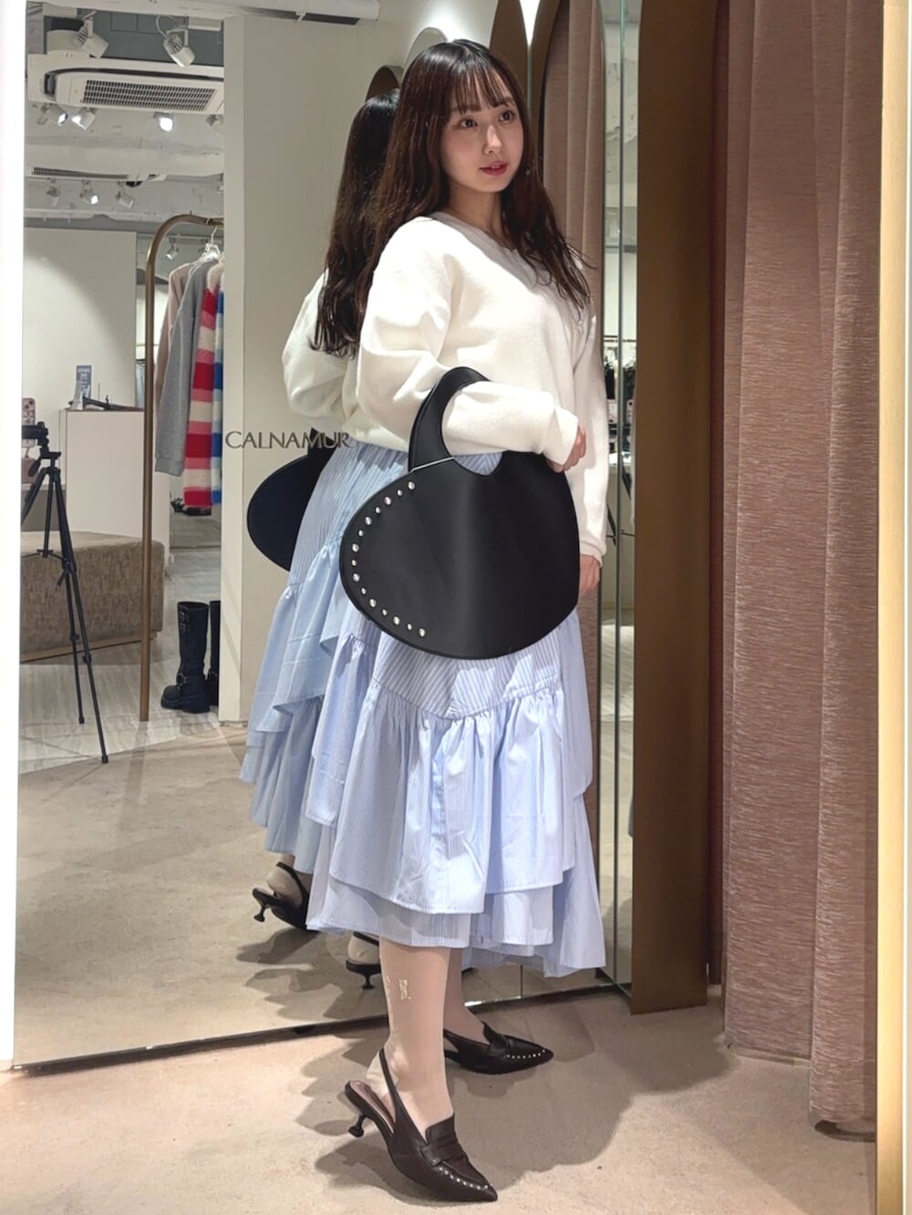 ブラウン系のサンダル、ホワイト系のニット/セーター、ブルー系のスカートを着用したレディースの春コーディネートの4枚目の写真