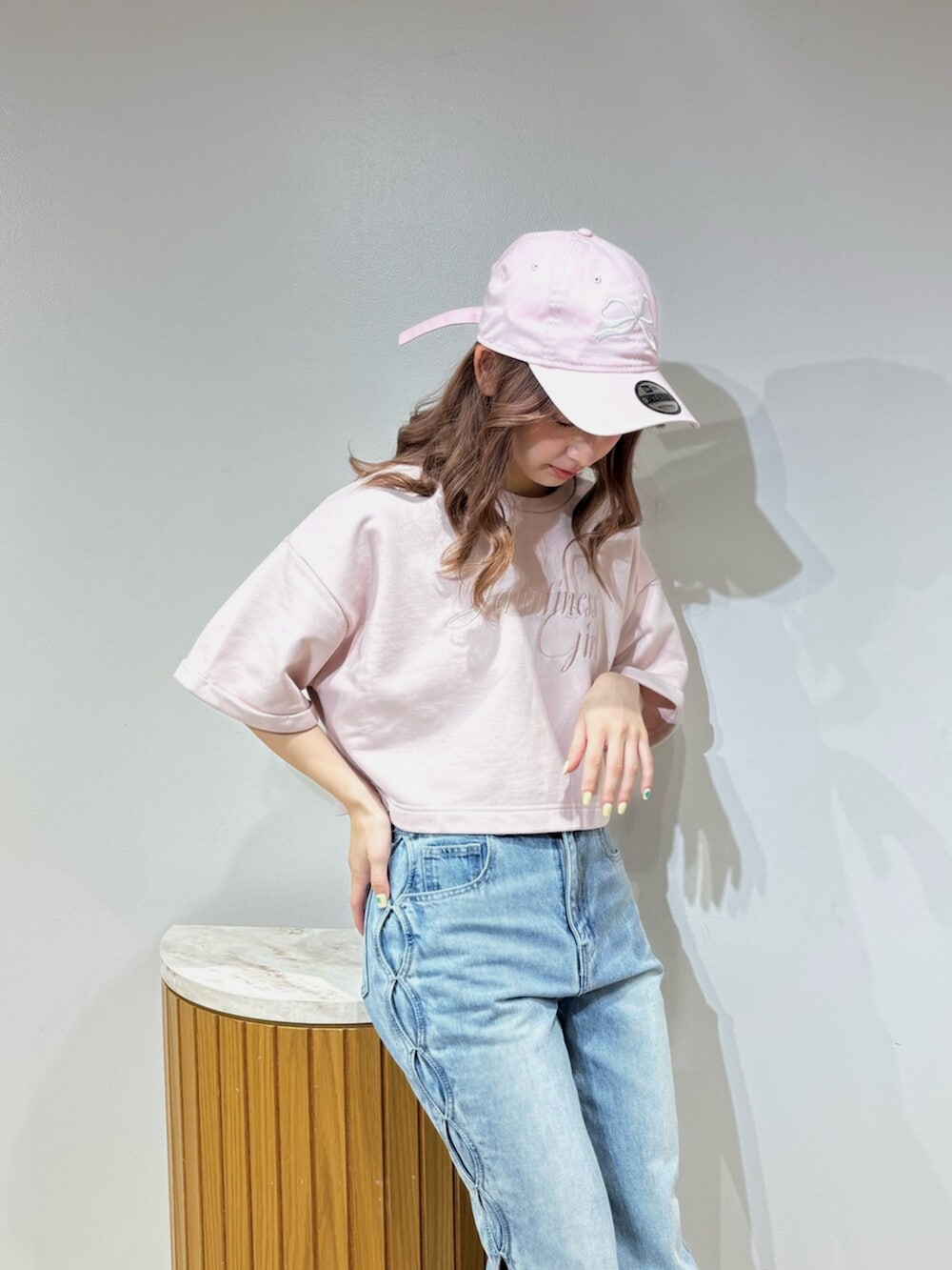 ブラック系のデニムパンツ、グレー系のスウェット、ブラック系のキャップを着用したレディースの春コーディネートの5枚目の写真