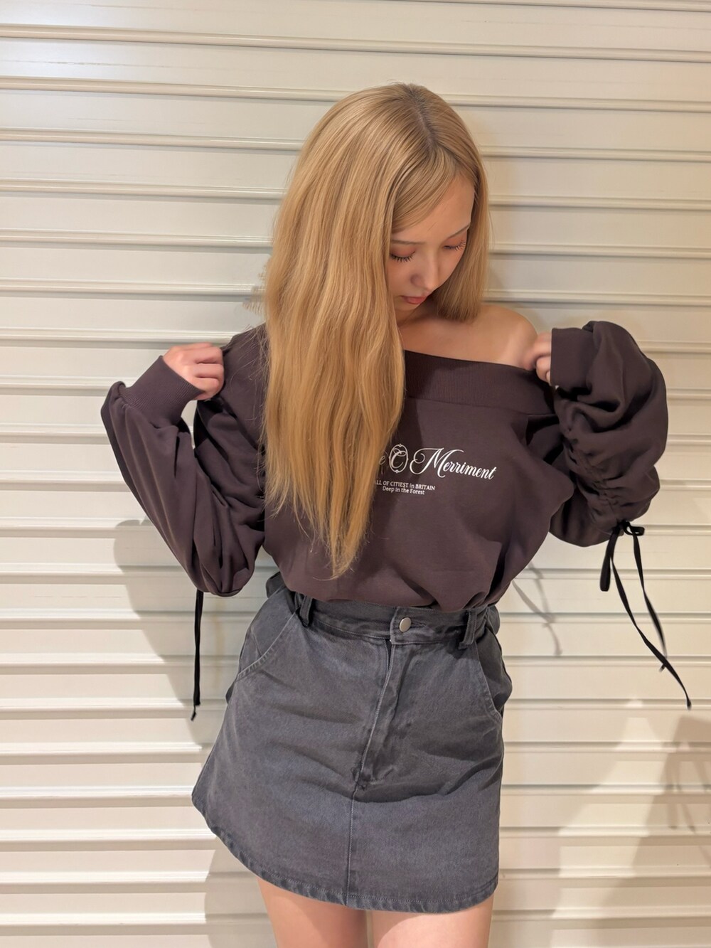 ブラック系のデニムスカート、ブラウン系のスウェット、ブラウン系のブーツを着用したレディースの秋コーディネートの5枚目の写真