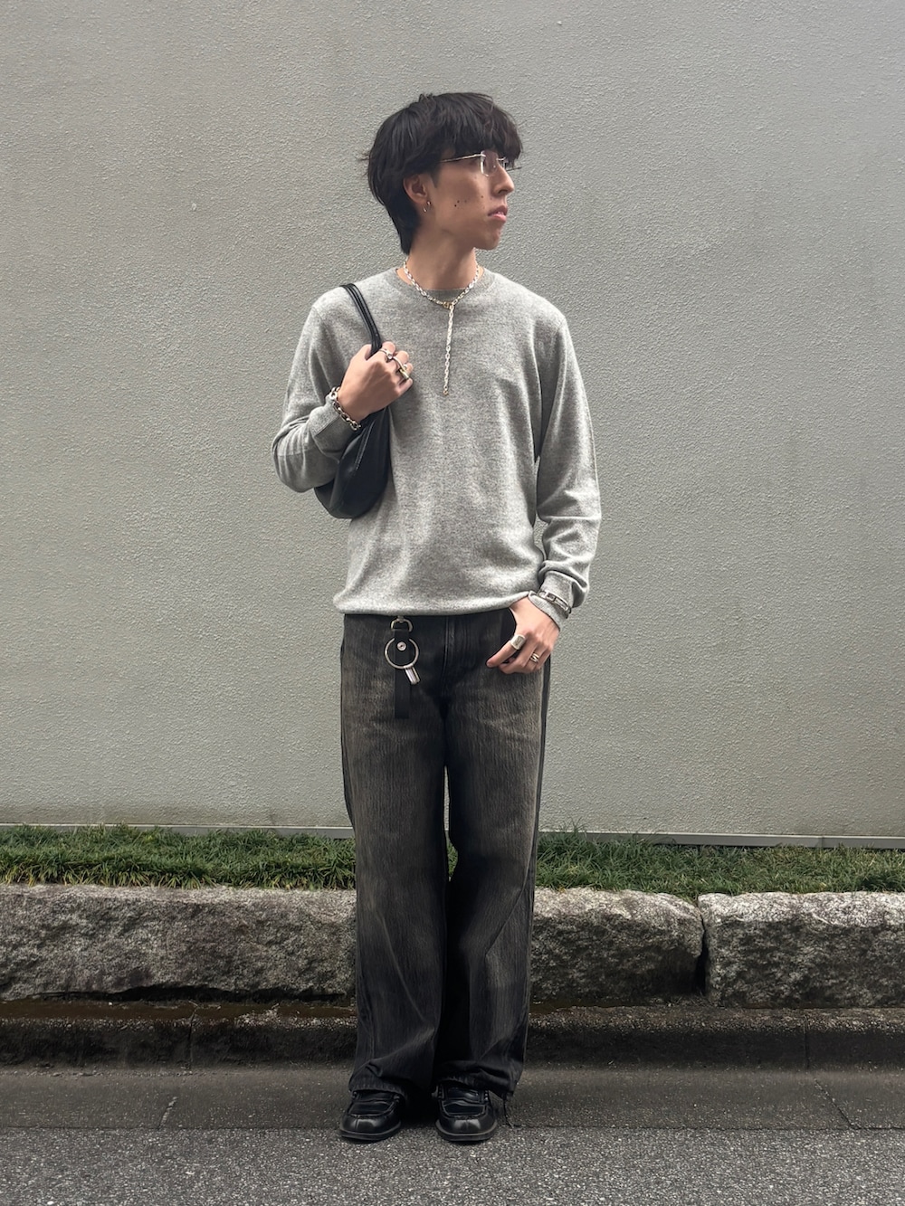 ブラック系のデニムパンツ、ブラック系のローファー、グレー系のニット/セーターを着用したメンズの秋コーディネートの2枚目の写真