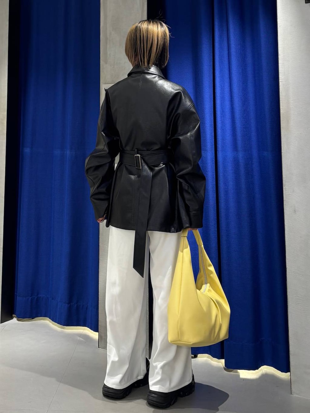 ブラック系のスニーカー、イエロー系のトートバッグ、ホワイト系のスラックスを着用したレディースの春コーディネートの4枚目の写真