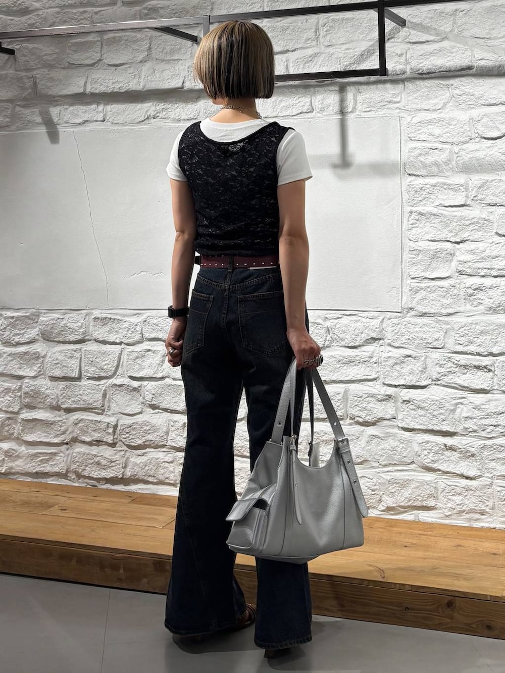 ブルー系のデニムパンツ、イエロー系のサンダル、シルバー系のハンドバッグを着用したレディースの春コーディネートの5枚目の写真