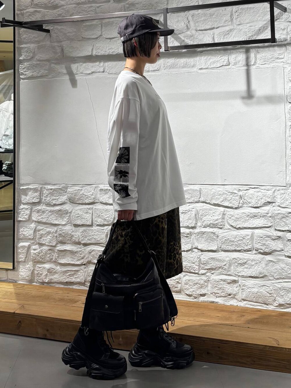 ブラック系のブーツ、その他のデニムパンツ、ブラック系のショルダーバッグを着用したレディースの春コーディネートの4枚目の写真