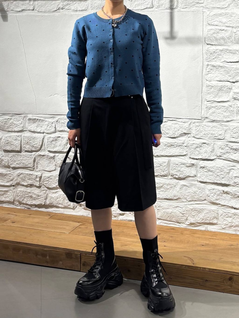 ブラック系のショルダーバッグ、ブラック系のその他パンツ、ブルー系のカーディガン/ボレロを着用したレディースの秋コーディネートの2枚目の写真