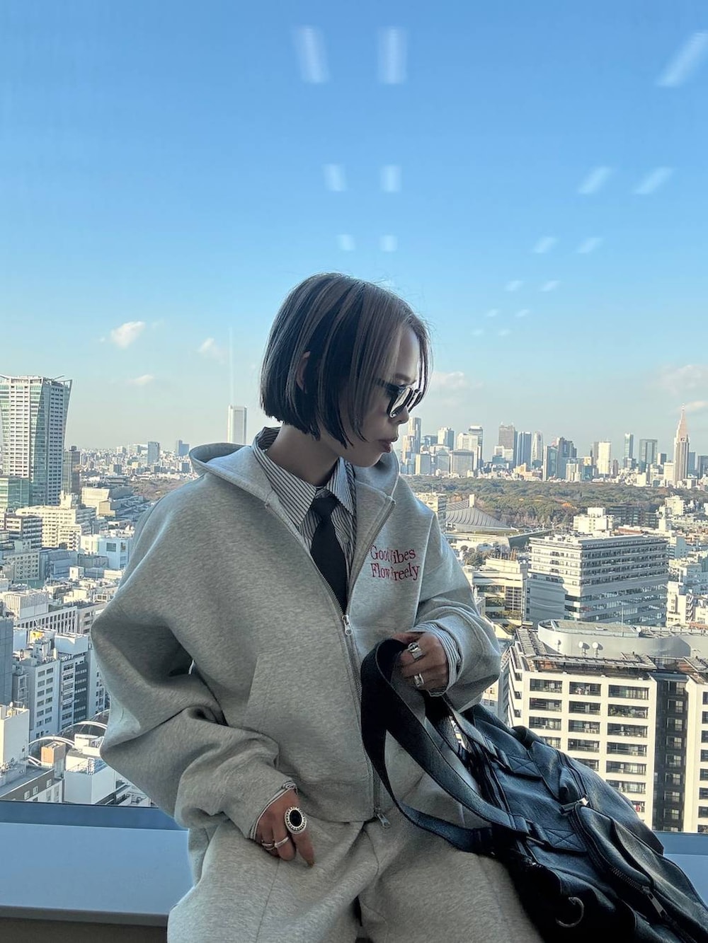 ブラック系のスニーカー、ブラック系のボストンバッグ、グレー系のパーカーを着用したレディースの冬コーディネートの4枚目の写真