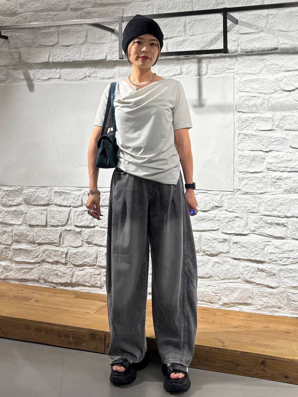 ブラック系のデニムパンツ、グレー系のサンダル、ベージュ系のTシャツ/カットソーを着用したレディースの夏コーディネートの2枚目の写真