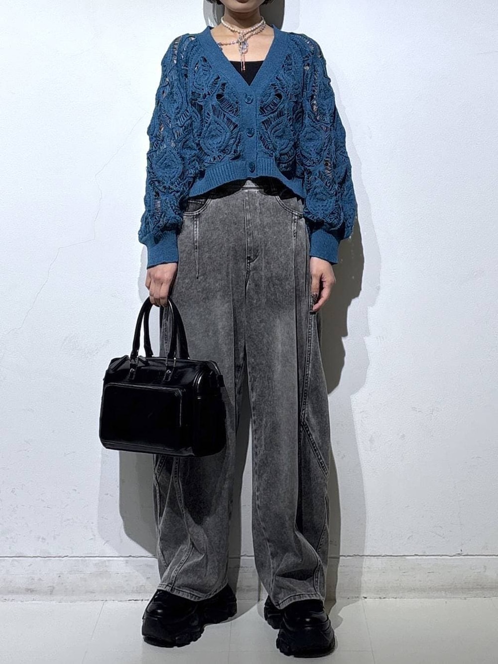 ブラック系のスニーカー、ブラック系のキャミソール、ブルー系のカーディガン/ボレロを着用したレディースの春コーディネートの3枚目の写真