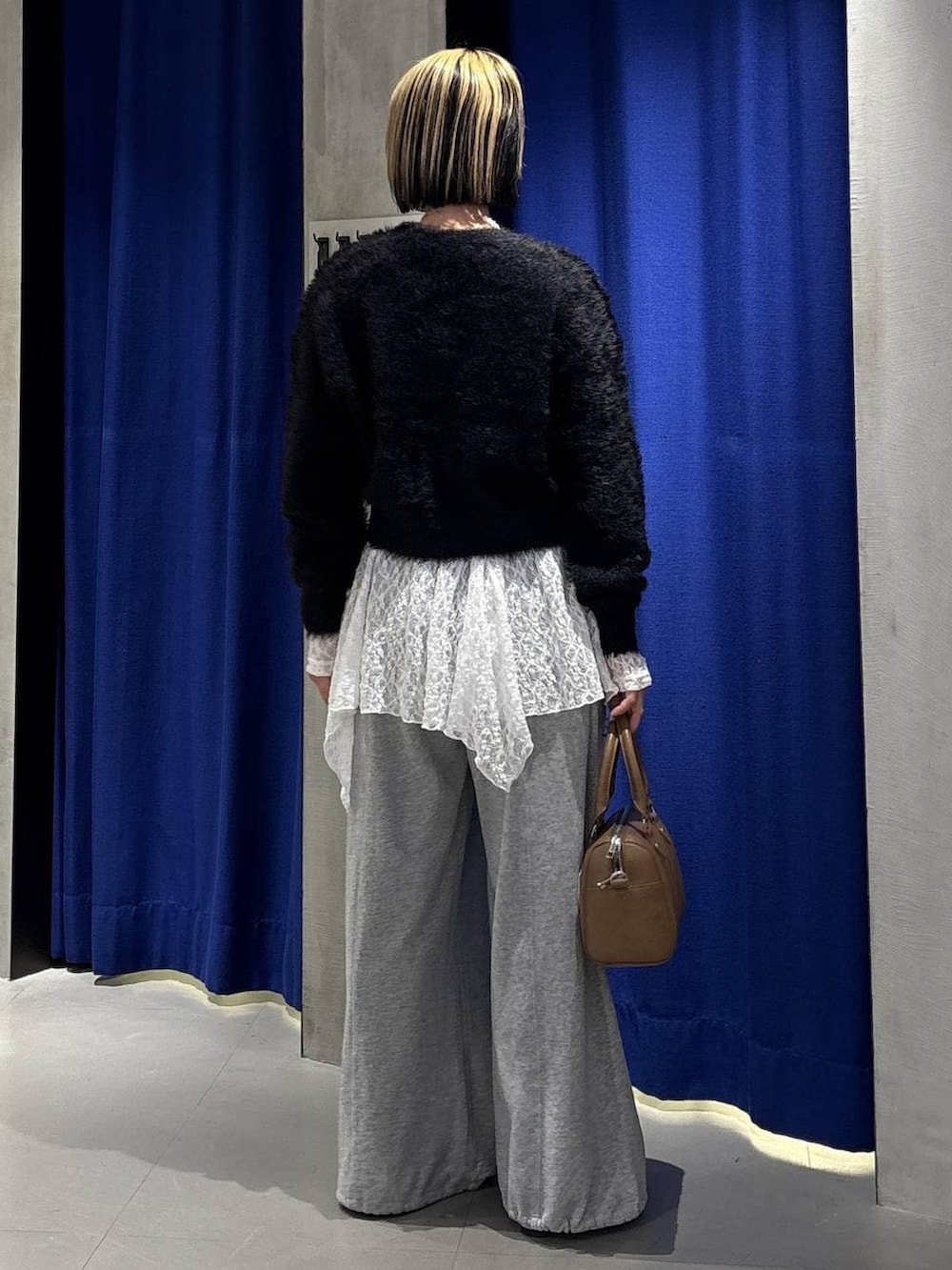 ブラウン系のボストンバッグ、グレー系のスウェットパンツ、シルバー系のスニーカーを着用したレディースの冬コーディネートの6枚目の写真