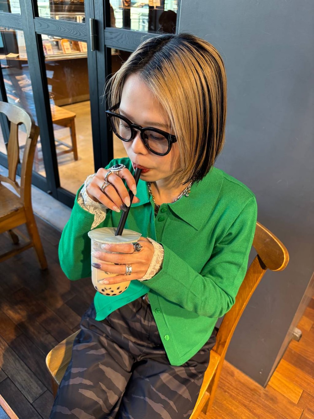 ブラック系のブーツ、ホワイト系のTシャツ/カットソー、ブラック系のハンドバッグを着用したレディースの春コーディネートの2枚目の写真