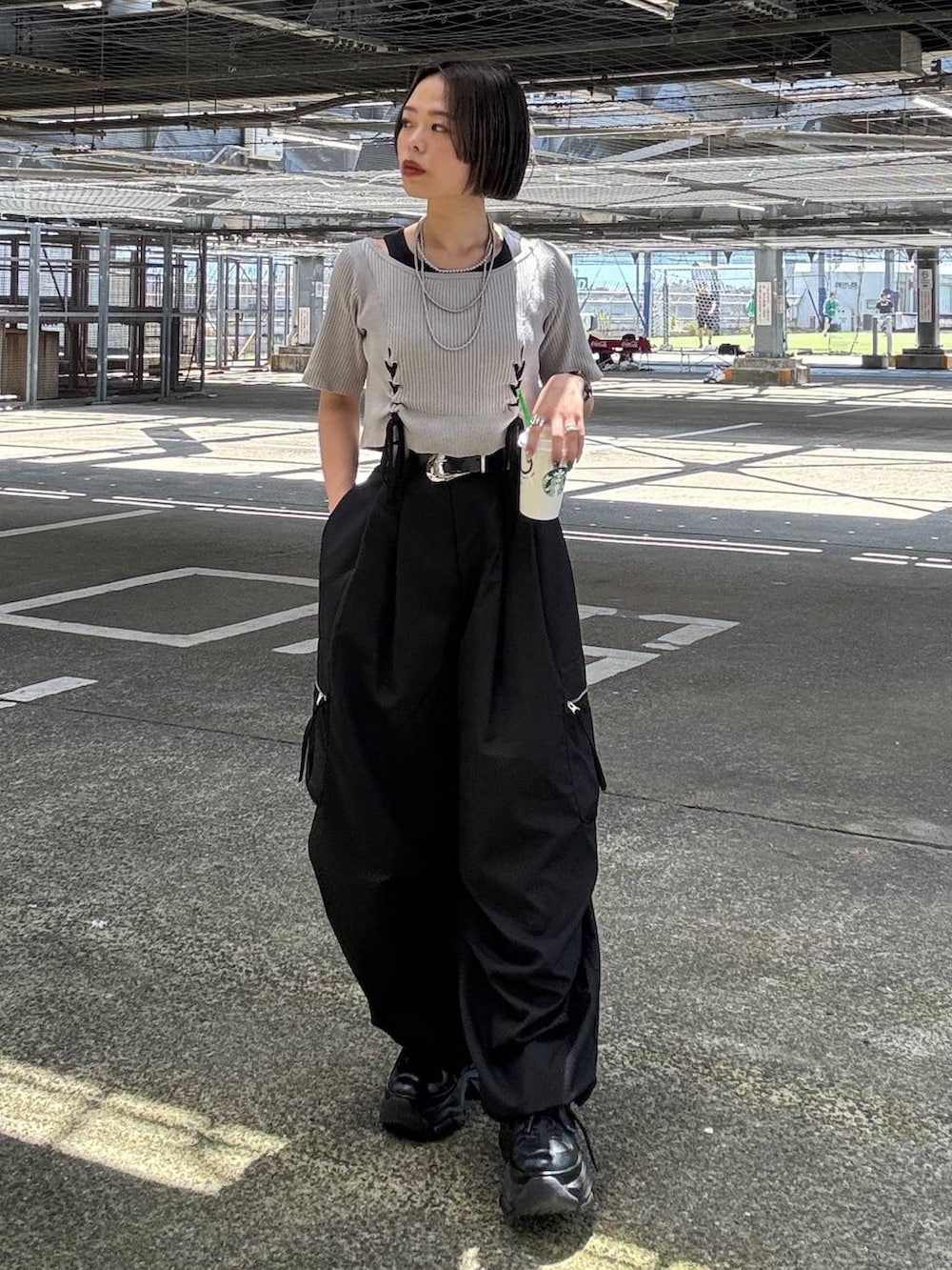 ブラック系のカーゴパンツ、グレー系のTシャツ/カットソー、ブラック系のスニーカーを着用したレディースの夏コーディネートの3枚目の写真