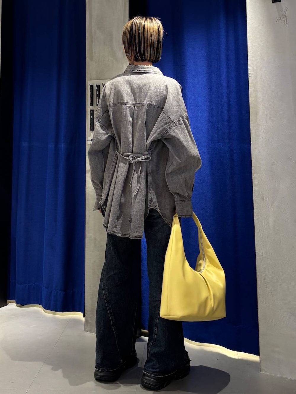 ブラック系のスニーカー、ブルー系のデニムパンツ、ブラック系のシャツ/ブラウスを着用したレディースの春コーディネートの5枚目の写真