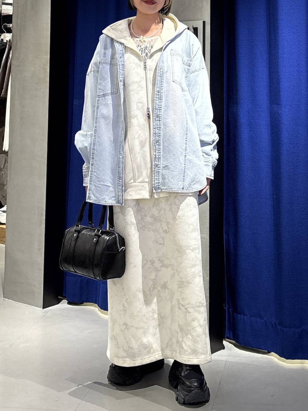 ブラック系のブーツ、ホワイト系のTシャツ/カットソー、ホワイト系のスカートを着用したレディースの冬コーディネートの2枚目の写真