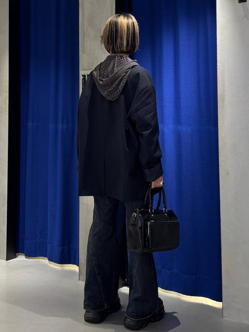 ブラック系のスニーカー、ブラック系のキャミソール、ブルー系のデニムパンツを着用したレディースの春コーディネートの4枚目の写真