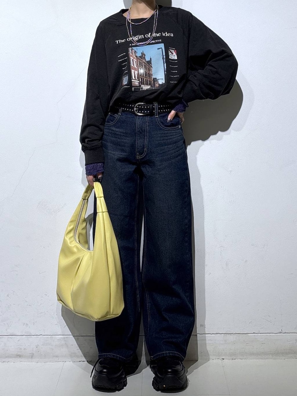 ブラック系のスニーカー、ブルー系のスラックス、イエロー系のトートバッグを着用したレディースの春コーディネートの3枚目の写真