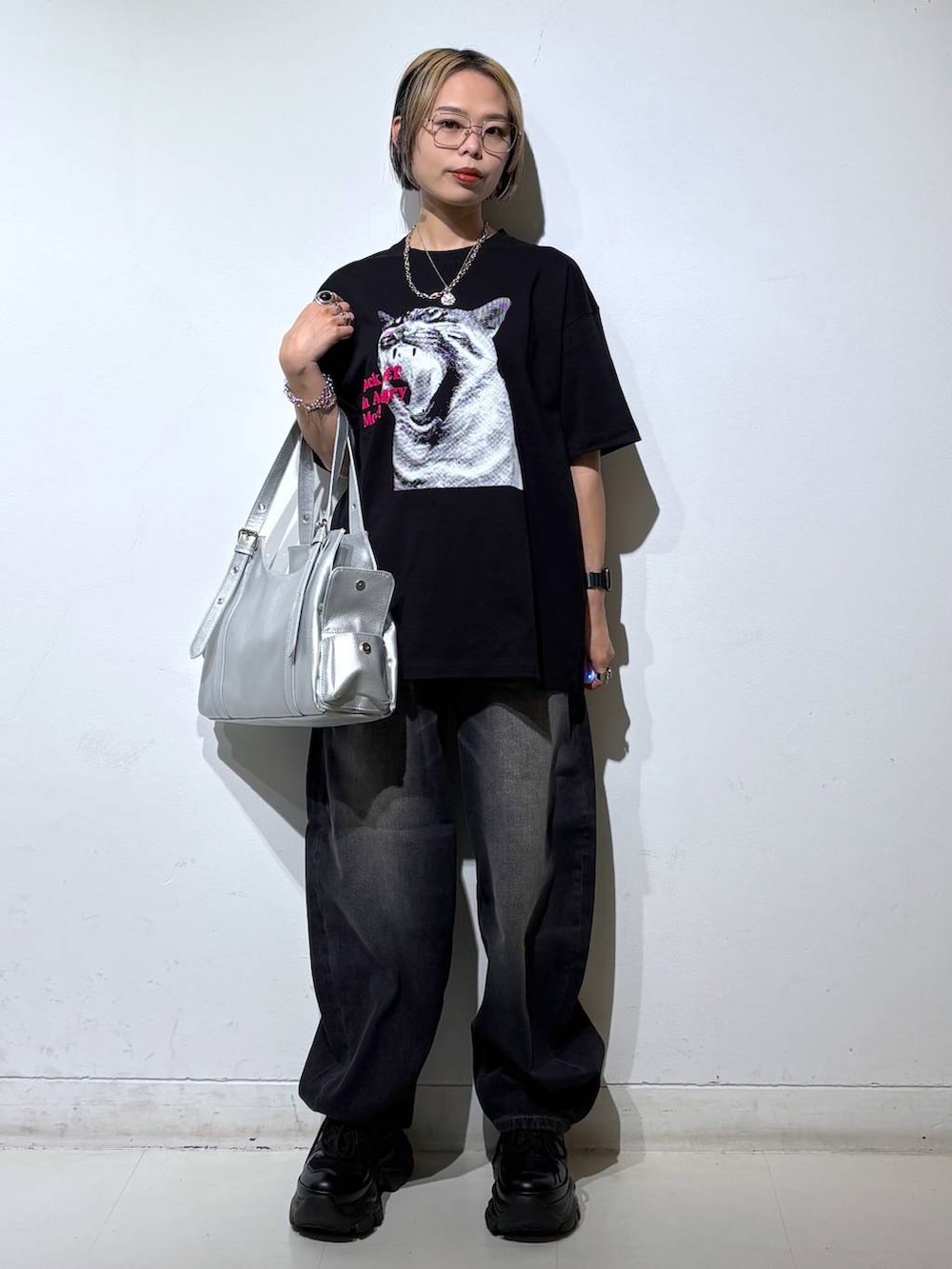 ブラック系のスニーカー、シルバー系のハンドバッグ、ブラック系のTシャツ/カットソーを着用したレディースの夏コーディネートの2枚目の写真