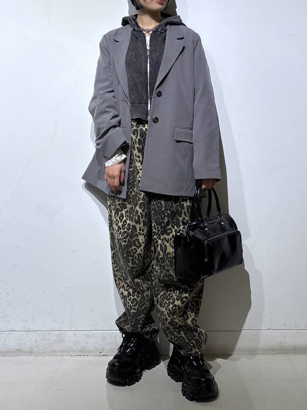 ブラック系のスニーカー、ホワイト系のTシャツ/カットソー、ブラウン系のデニムパンツを着用したレディースの冬コーディネートの2枚目の写真