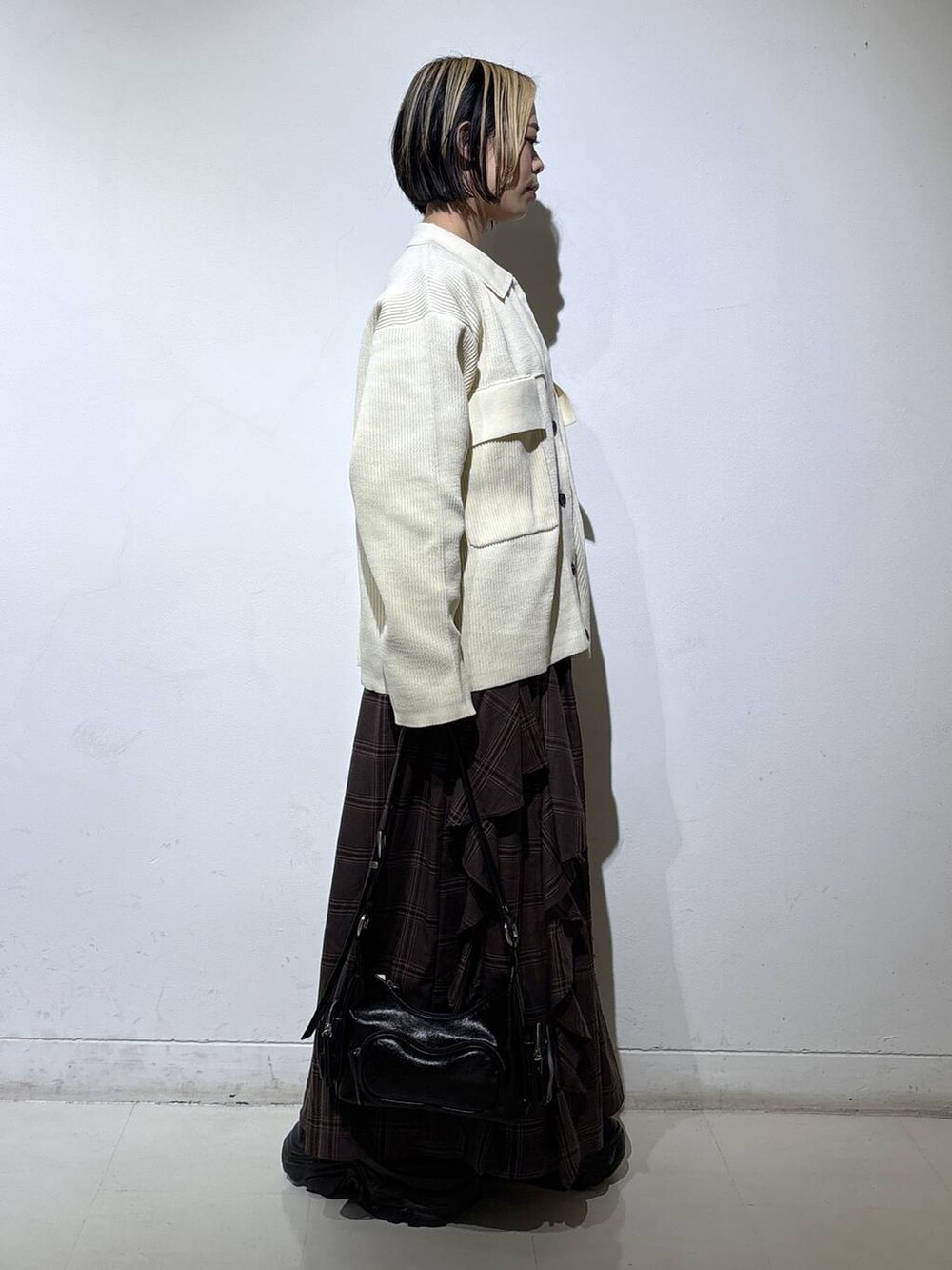 ブラック系のブーツ、ホワイト系のブルゾン、ブラウン系のスカートを着用したレディースの冬コーディネートの3枚目の写真