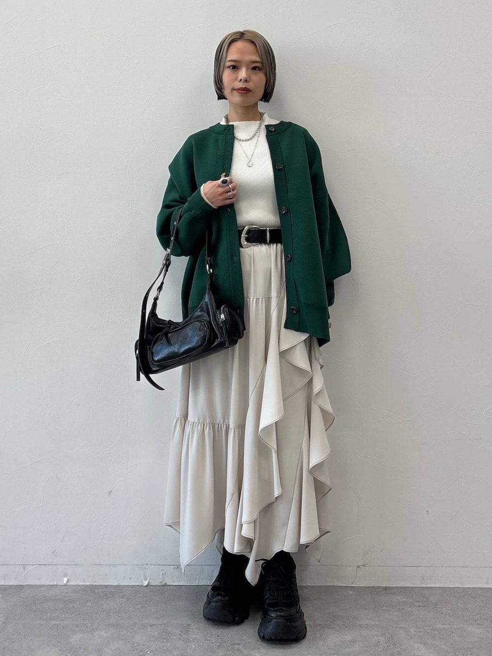 ブラック系のスニーカー、ブラック系のショルダーバッグ、ホワイト系のニット/セーターを着用したレディースの冬コーディネートの4枚目の写真