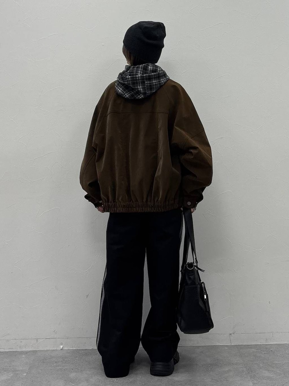 ブラック系のスニーカー、グリーン系のボストンバッグ、ブラウン系のブルゾンを着用したレディースの冬コーディネートの5枚目の写真