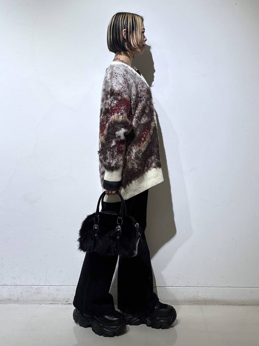 ブラック系のスニーカー、ブラック系のデニムパンツ、ブラック系のニット/セーターを着用したレディースの冬コーディネートの3枚目の写真