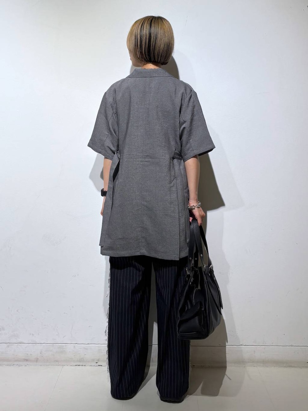 ブラック系のサンダル、グレー系のテーラードジャケット、ホワイト系のTシャツ/カットソーを着用したレディースの夏コーディネートの5枚目の写真