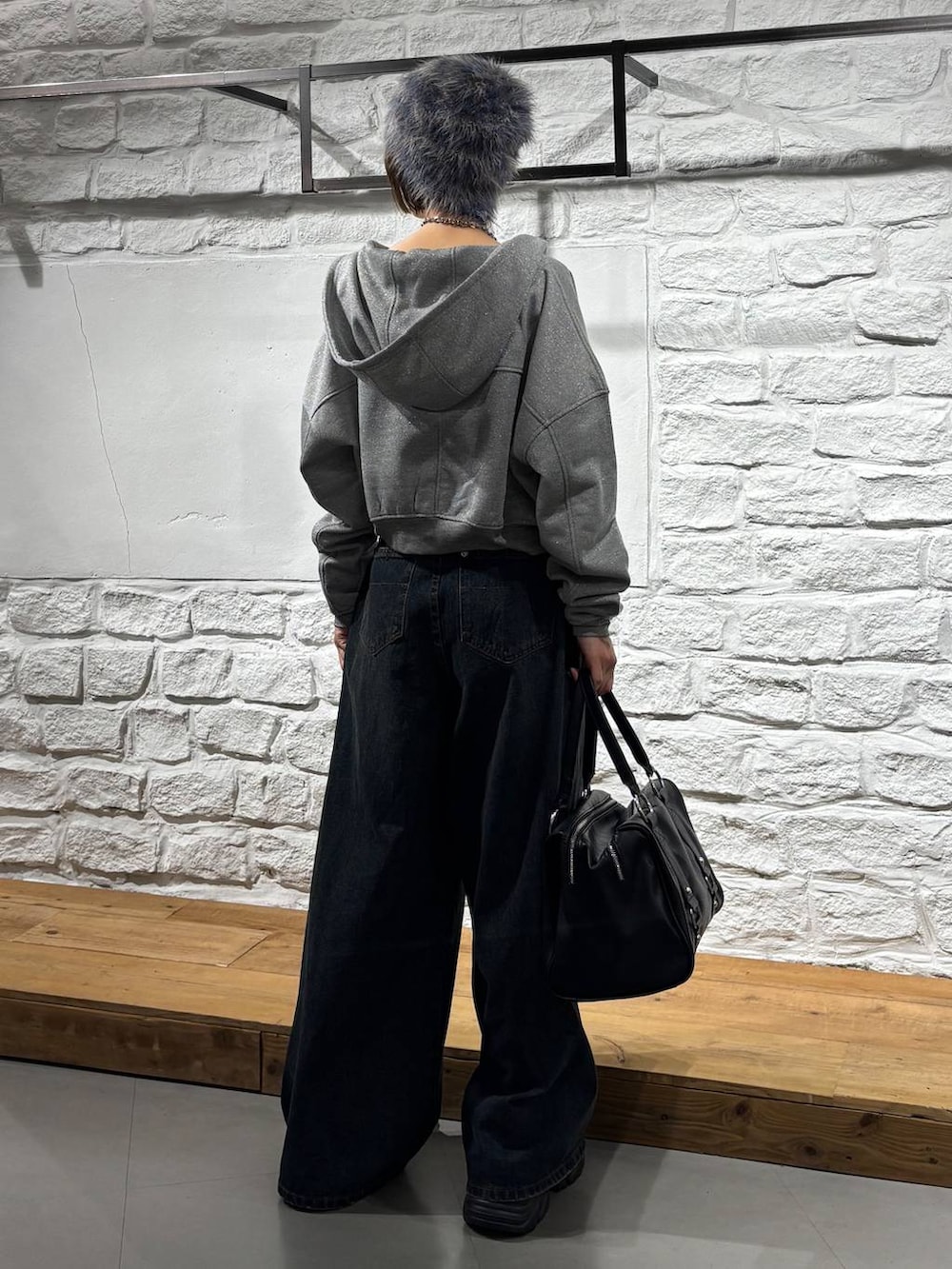 ブルー系のデニムパンツ、ブラック系のボストンバッグ、グレー系のパーカーを着用したレディースの秋コーディネートの6枚目の写真