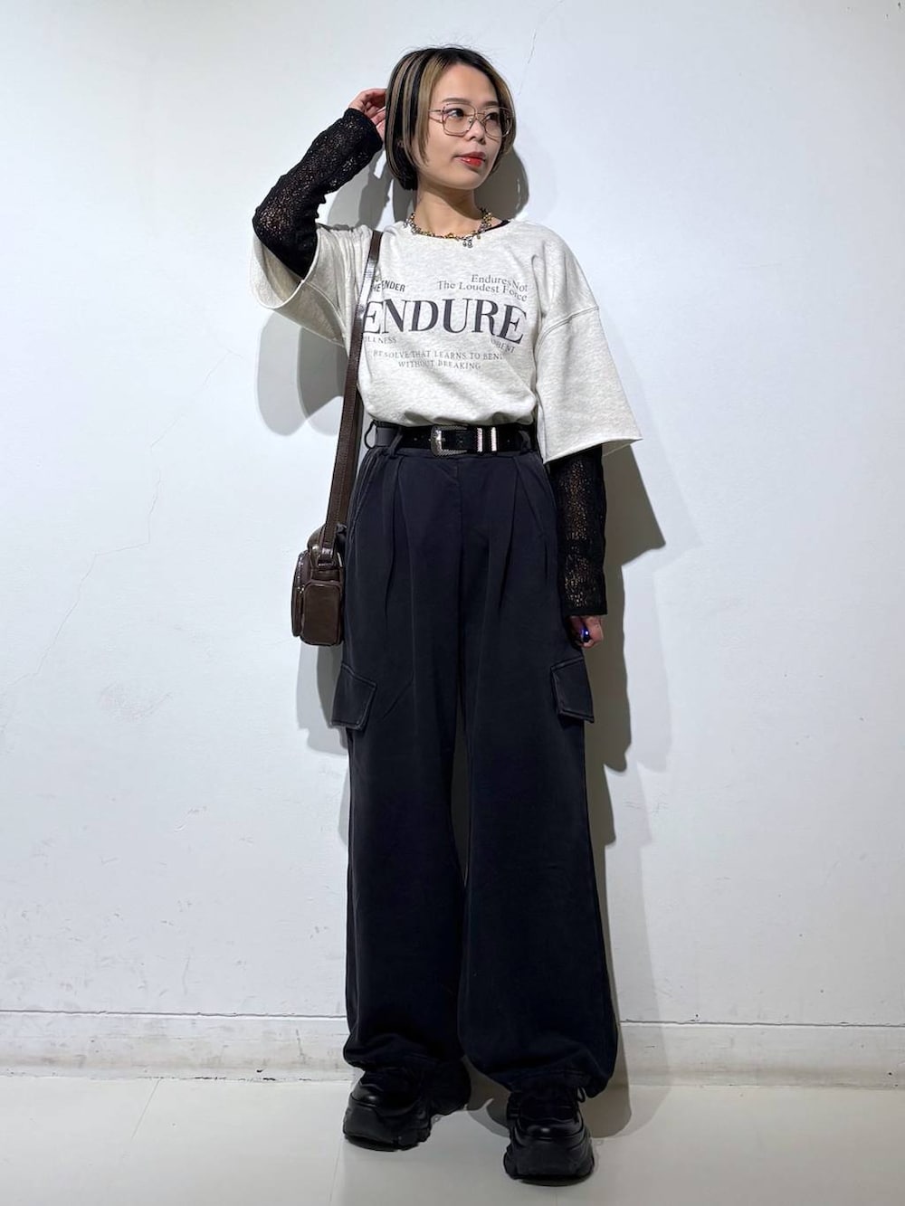 ブラック系のスニーカー、ブラウン系のショルダーバッグ、ブラック系のTシャツ/カットソーを着用したレディースの春コーディネートの2枚目の写真