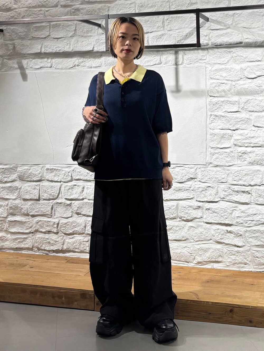 ブルー系のポロシャツ、ブラック系のカーゴパンツ、ブラック系のスニーカーを着用したレディースの夏コーディネートの2枚目の写真