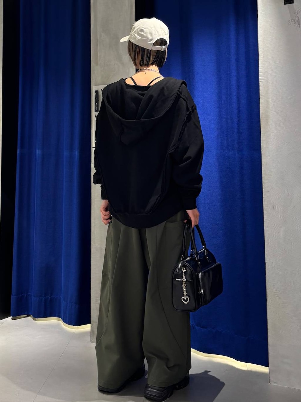 ブラック系のショルダーバッグ、ブラック系のタンクトップ、グリーン系のカーゴパンツを着用したレディースの春コーディネートの6枚目の写真