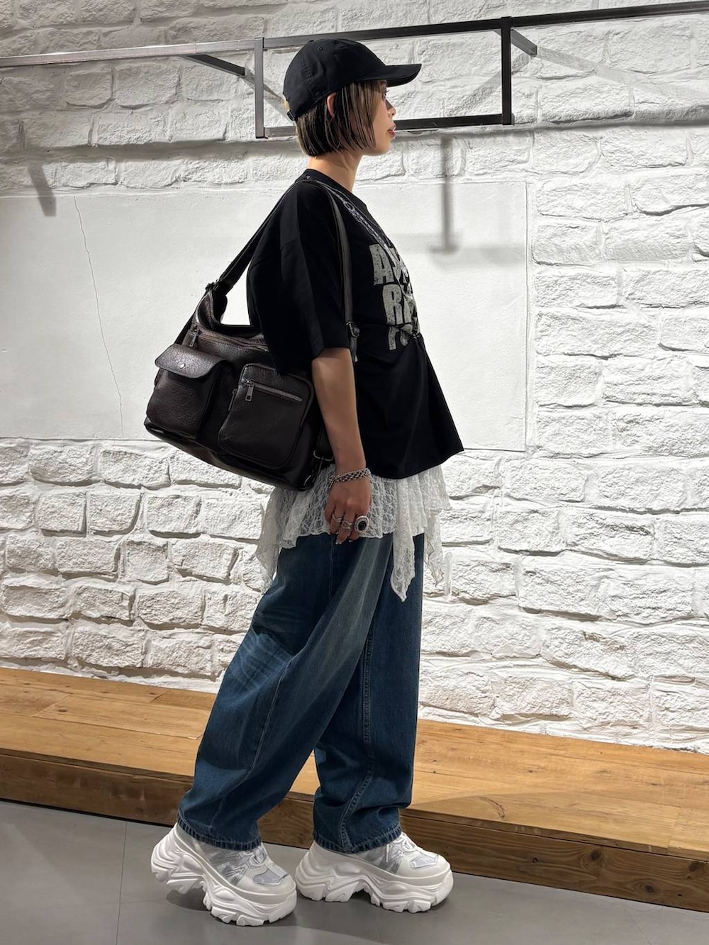 ブラック系のTシャツ/カットソー、ホワイト系のスニーカー、ブラウン系のショルダーバッグを着用したレディースの夏コーディネートの5枚目の写真
