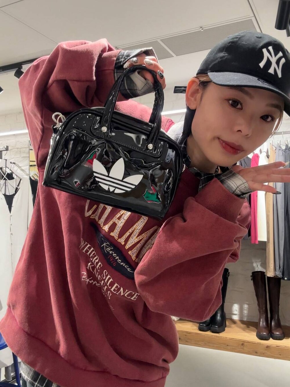 ブラック系のブーツ、レッド系のスウェット、ブラック系のTシャツ/カットソーを着用したレディースの秋コーディネートの6枚目の写真