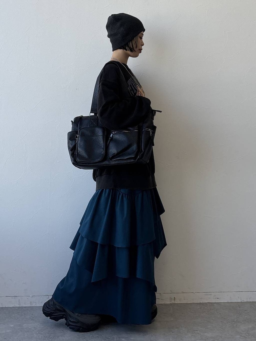 グレー系のスニーカー、ブラック系のボストンバッグ、ブルー系のスカートを着用したレディースの冬コーディネートの5枚目の写真