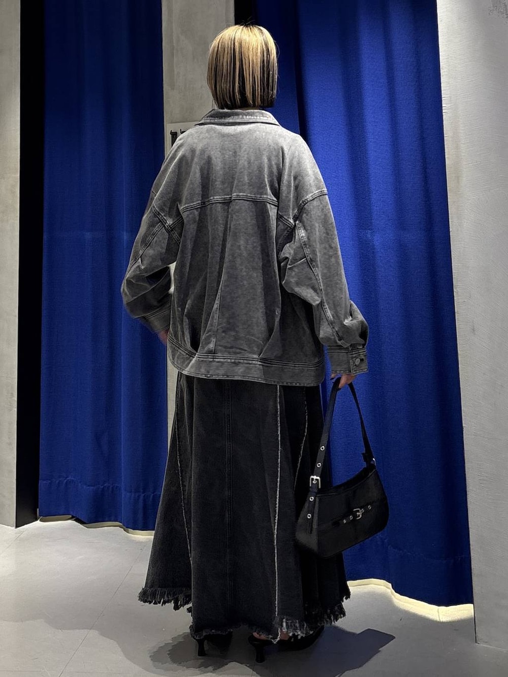 ブラック系のハンドバッグ、ブラック系のブルゾン、ブラック系のサンダルを着用したレディースの春コーディネートの4枚目の写真