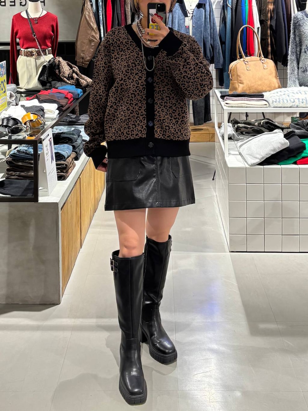 ブラック系のブーツ、ブラウン系のカーディガン/ボレロ、ブラック系のスカートを着用したレディースの秋コーディネートの5枚目の写真