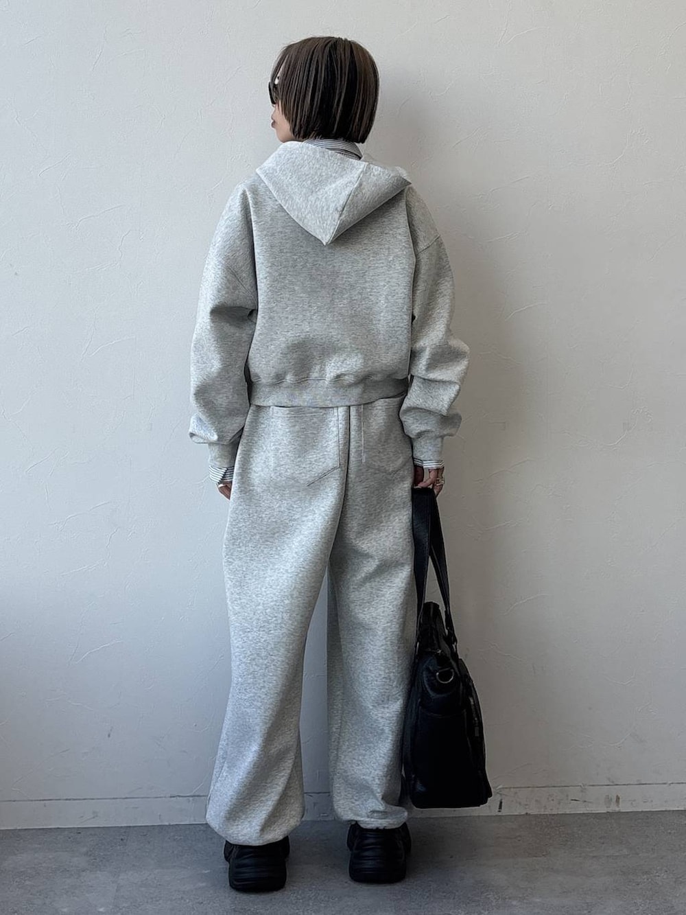 ブラック系のスニーカー、ブラック系のボストンバッグ、グレー系のパーカーを着用したレディースの冬コーディネートの9枚目の写真