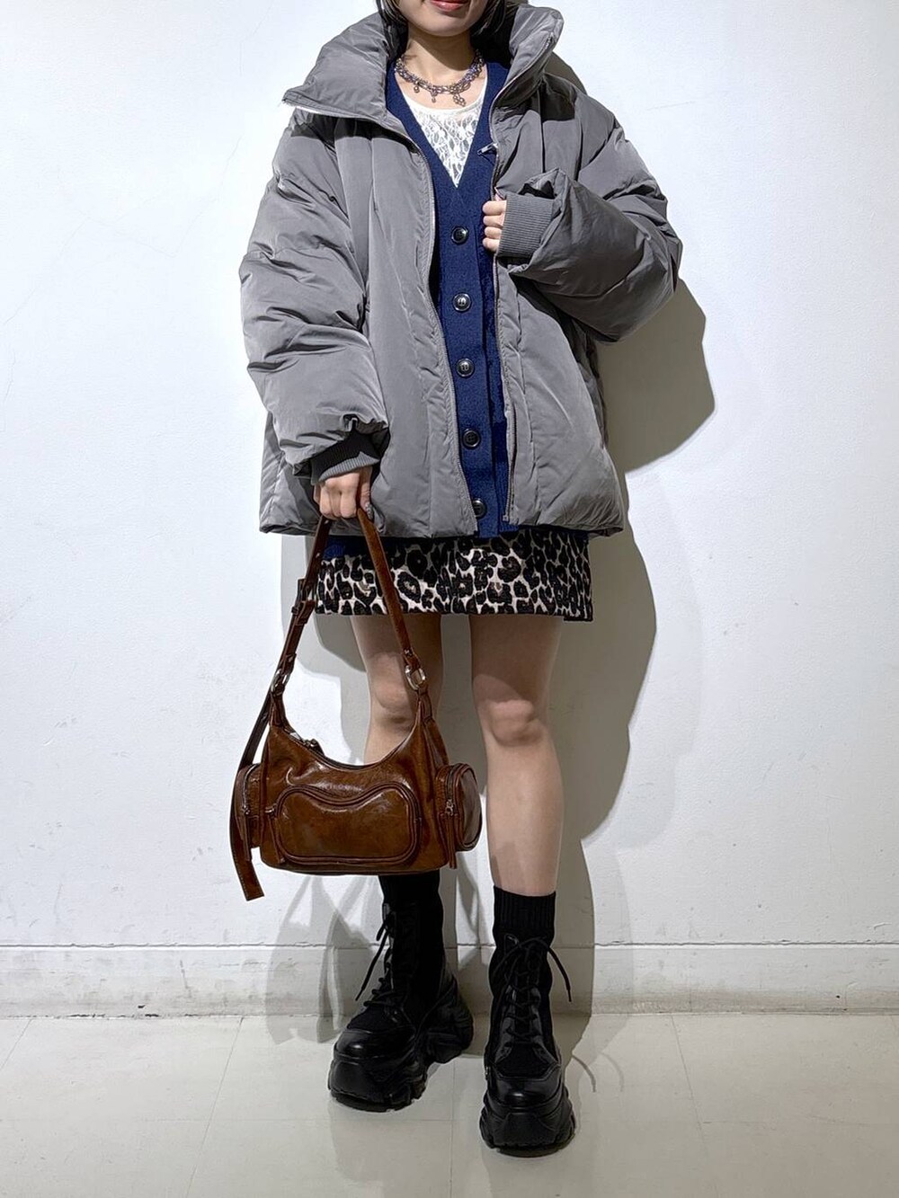 ブラック系のブーツ、グレー系のブルゾン、ホワイト系のTシャツ/カットソーを着用したレディースの冬コーディネートの2枚目の写真