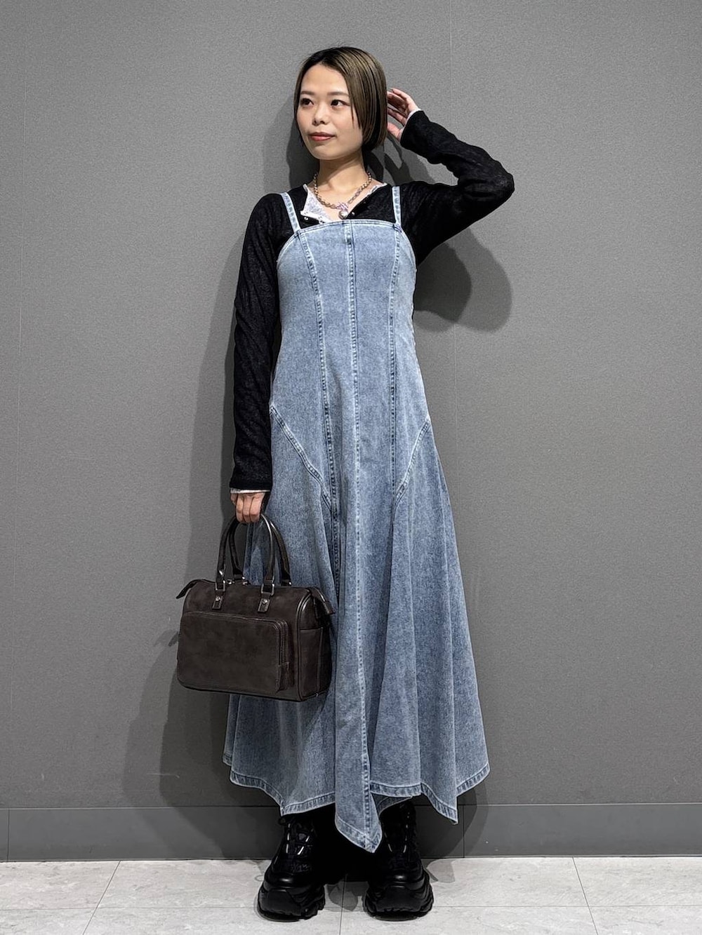 ブラック系のスニーカー、グレー系のショルダーバッグ、ブルー系のワンピースを着用したレディースの春コーディネートの3枚目の写真