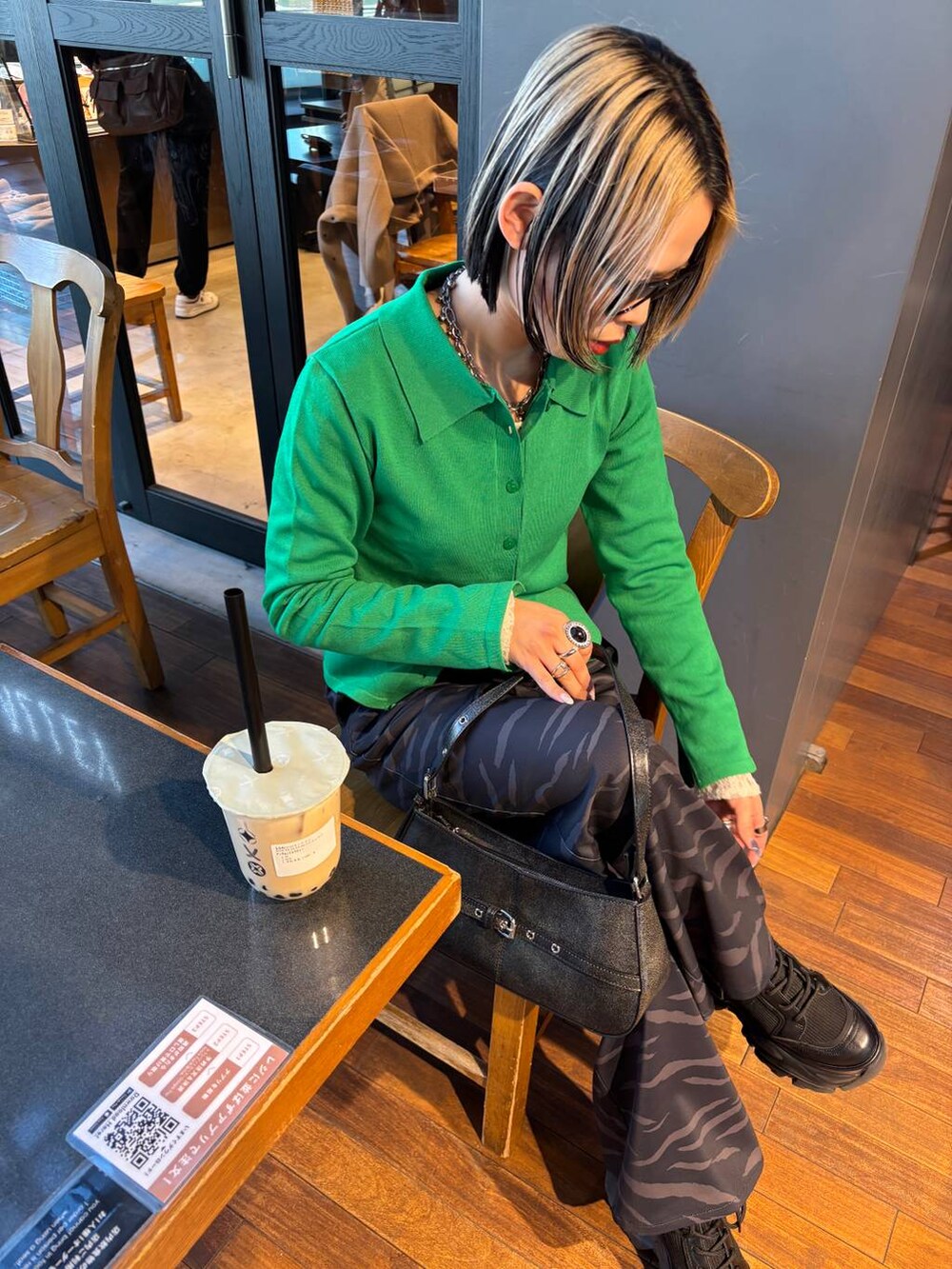 ブラック系のブーツ、ホワイト系のTシャツ/カットソー、ブラック系のハンドバッグを着用したレディースの春コーディネートの3枚目の写真