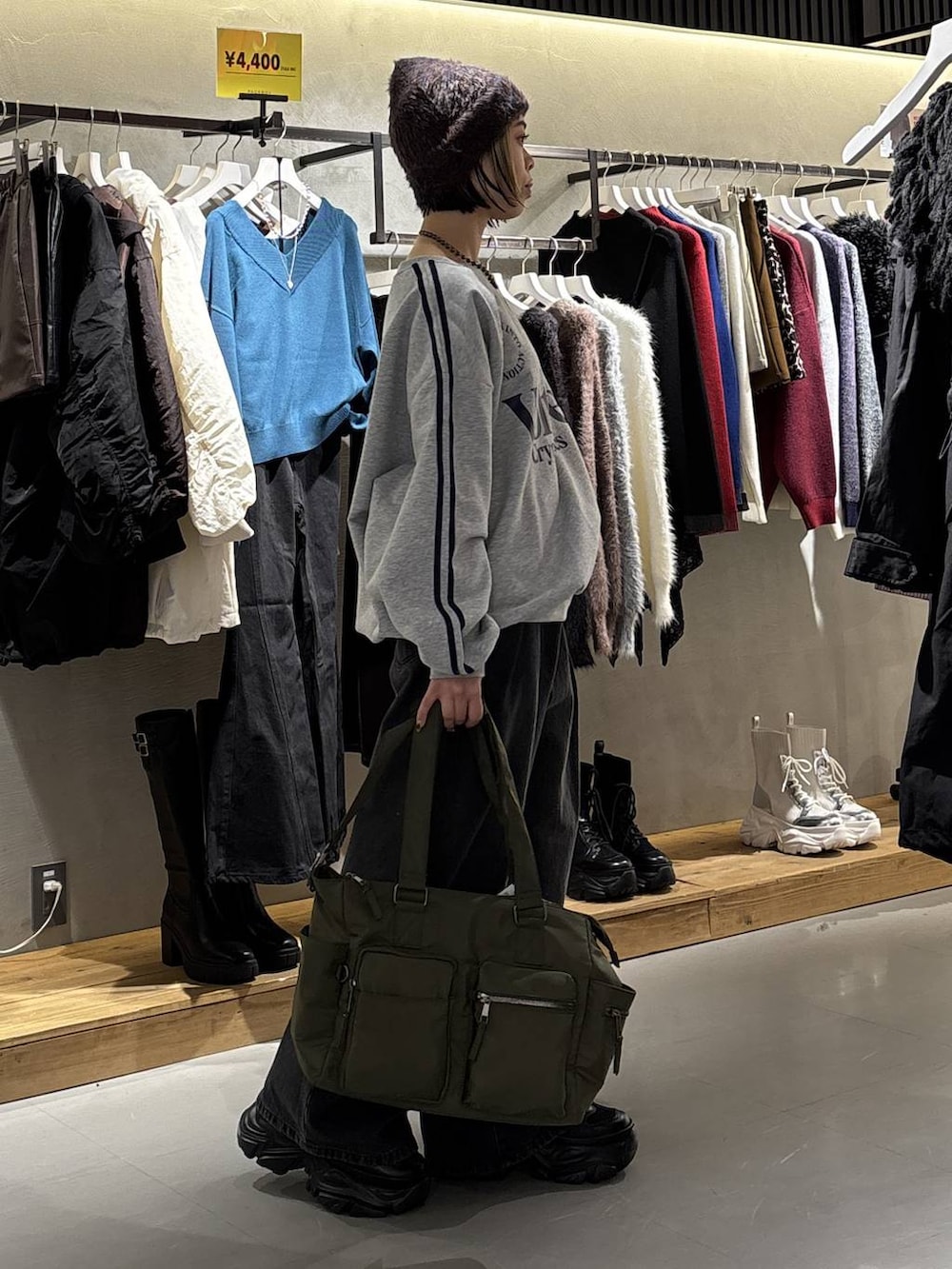 ブラック系のスニーカー、ブラック系のデニムパンツ、グリーン系のボストンバッグを着用したレディースの冬コーディネートの3枚目の写真