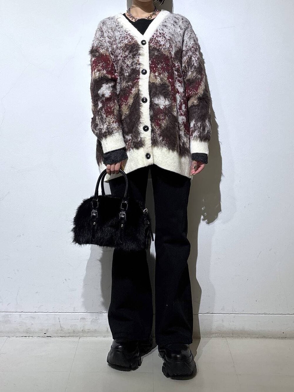 ブラック系のスニーカー、ブラック系のデニムパンツ、ブラック系のニット/セーターを着用したレディースの冬コーディネートの2枚目の写真