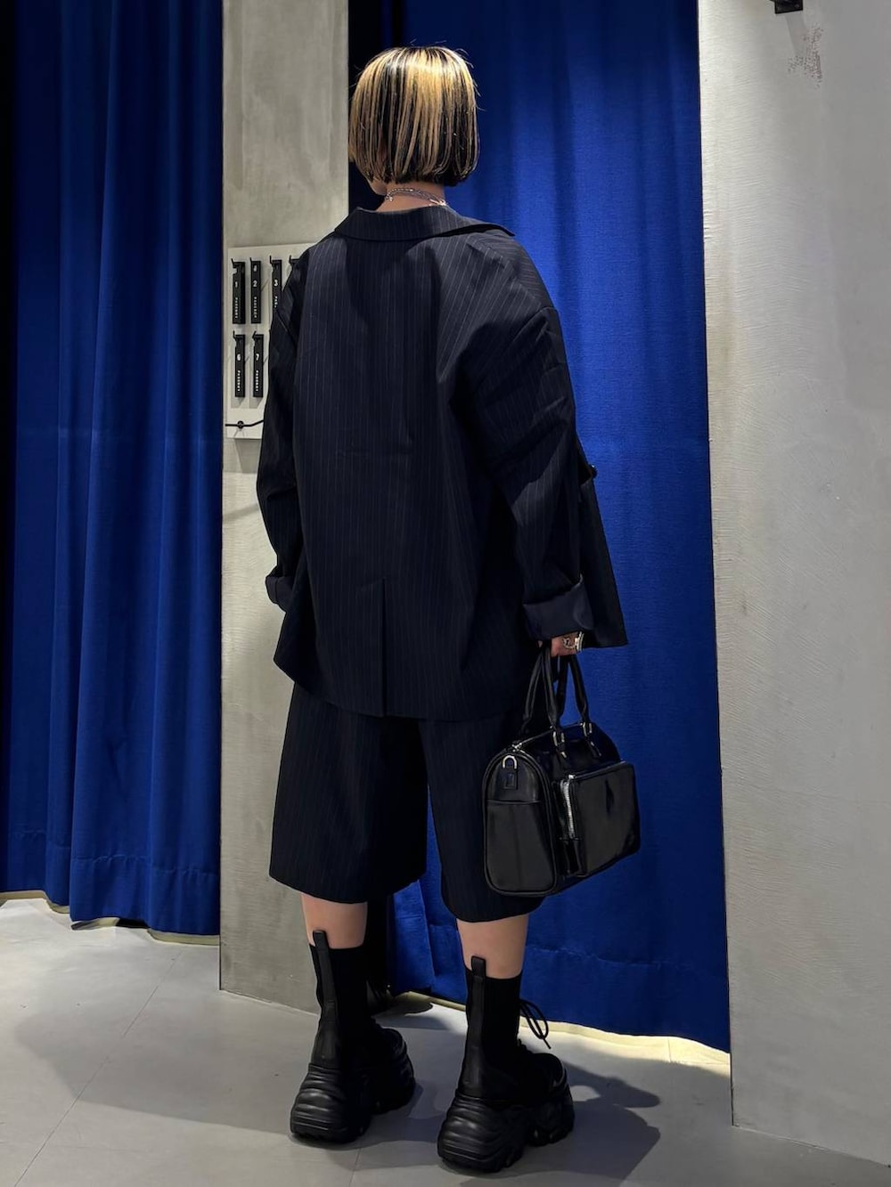 ブラック系のブーツ、ブラック系のショルダーバッグ、ホワイト系のTシャツ/カットソーを着用したレディースの春コーディネートの4枚目の写真