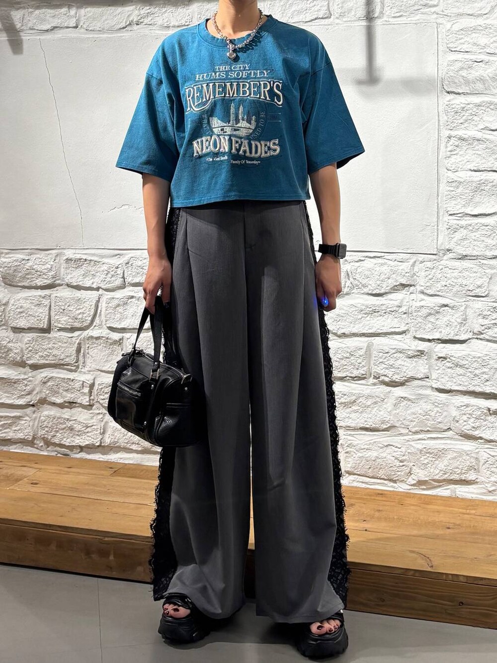 ブラック系のショルダーバッグ、ブルー系のTシャツ/カットソー、ブラック系のサンダルを着用したレディースの夏コーディネートの3枚目の写真