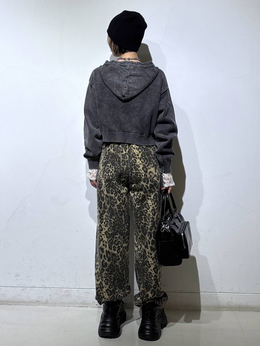 ブラック系のスニーカー、ホワイト系のTシャツ/カットソー、ブラウン系のデニムパンツを着用したレディースの冬コーディネートの5枚目の写真