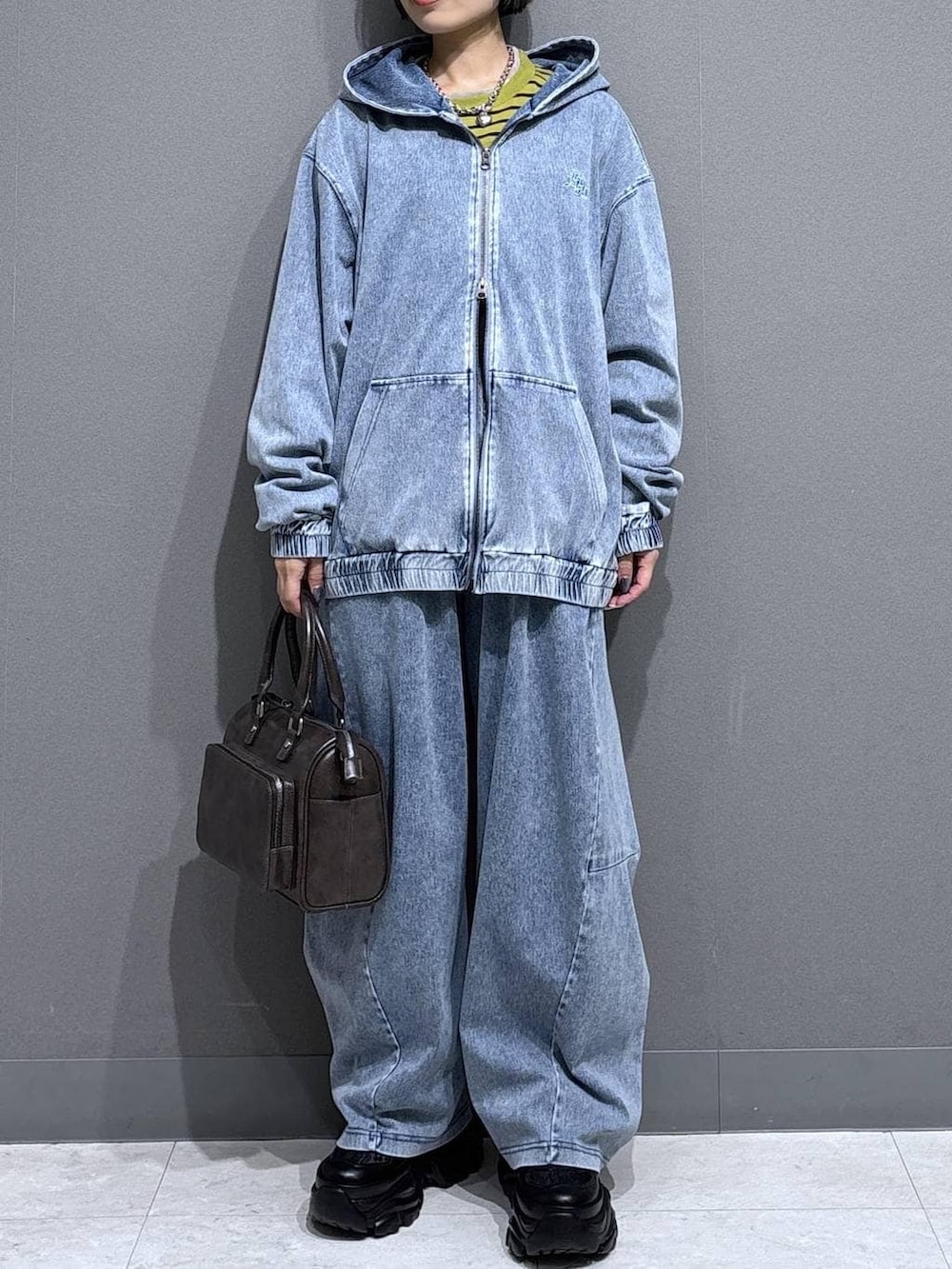 ブラック系のスニーカー、グレー系のショルダーバッグ、イエロー系のTシャツ/カットソーを着用したレディースの春コーディネートの2枚目の写真