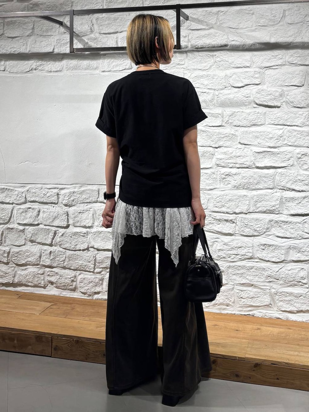 ブラウン系のデニムパンツ、ブラック系のショルダーバッグ、ブラック系のTシャツ/カットソーを着用したレディースの夏コーディネートの5枚目の写真